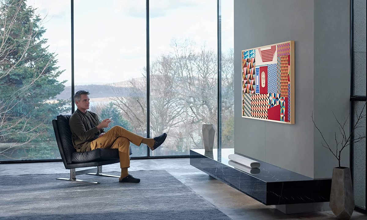 Man watching SAMSUNG 55-Inch Class Frame Series in living room.