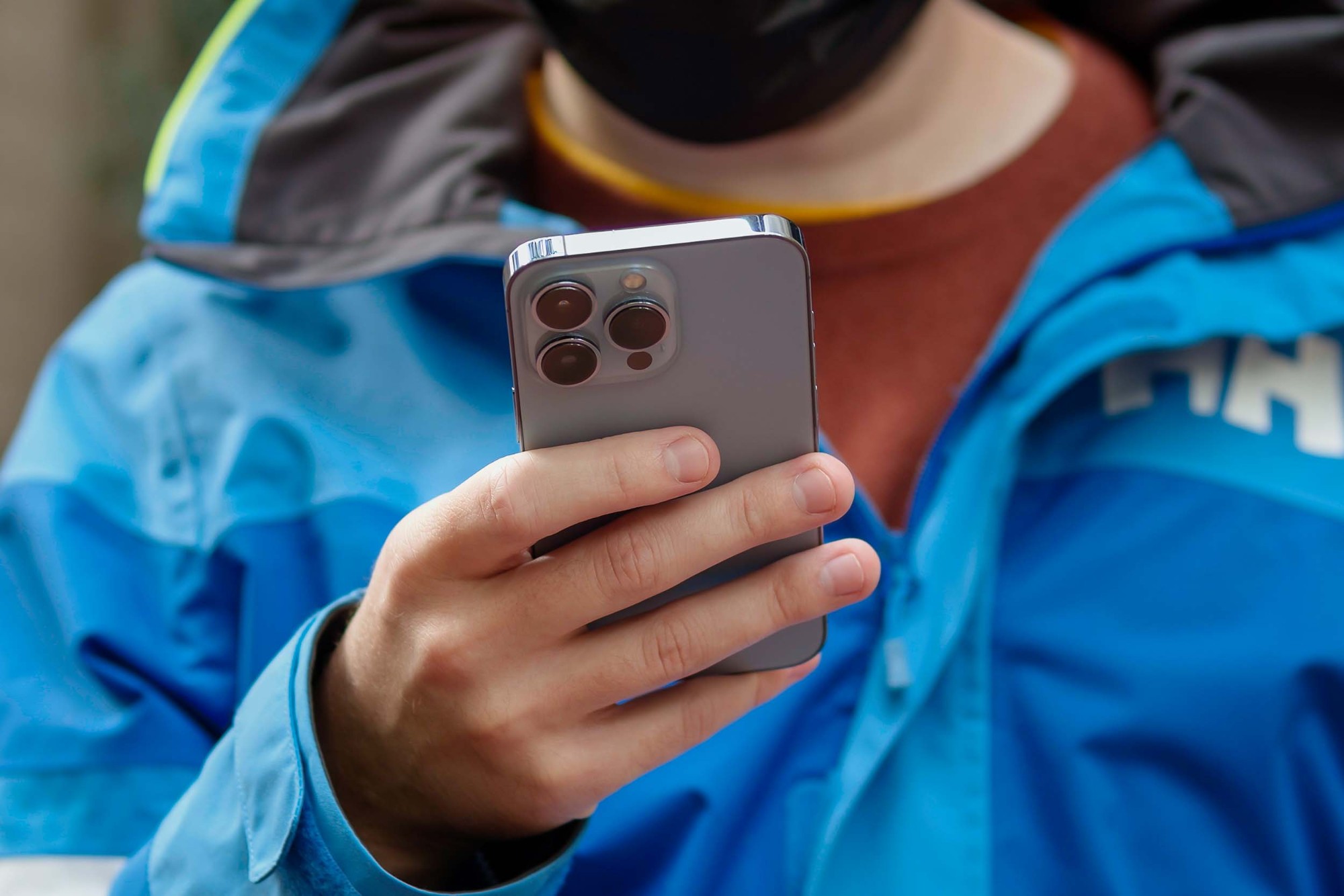 Homem segurando o iPhone 13 Pro mostrando seu painel traseiro.