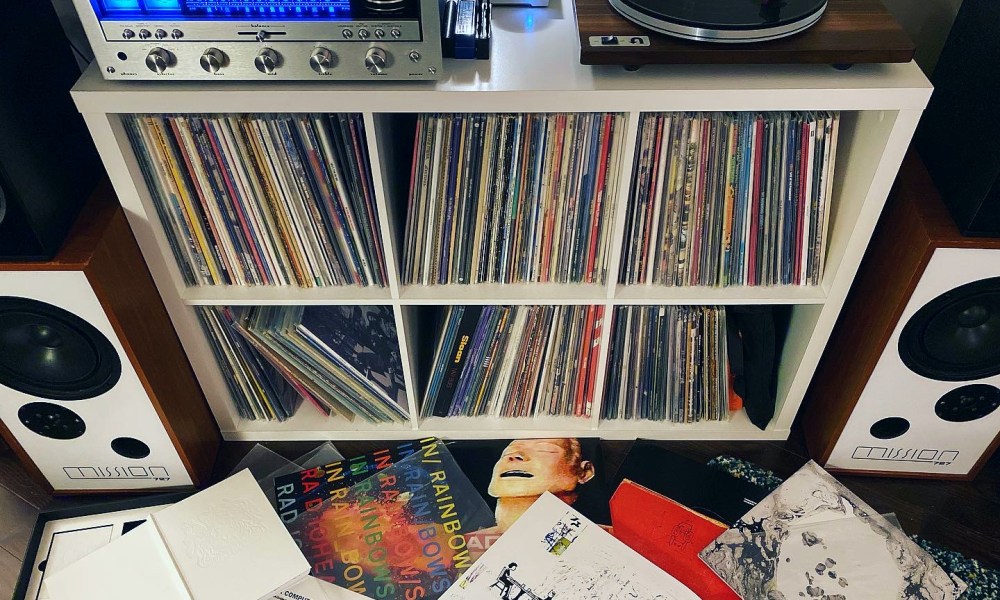 A vinyl collection shelf with receiver and turntable.