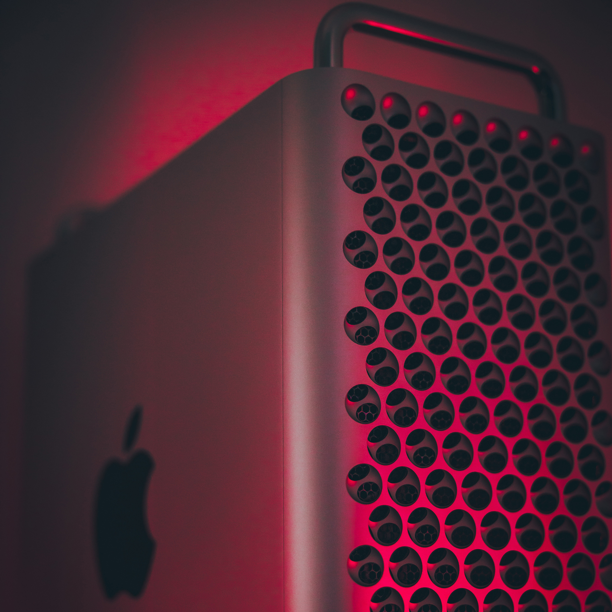 L'Apple Mac Pro 2019 est placé sur un fond rouge foncé.