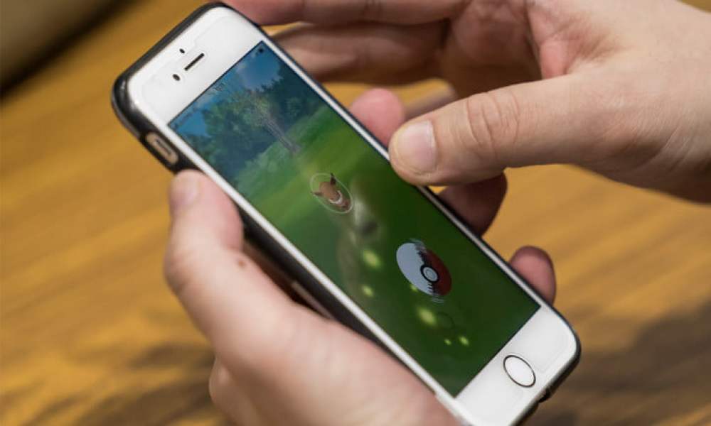 Person playing Pokémon GO on smartphone.