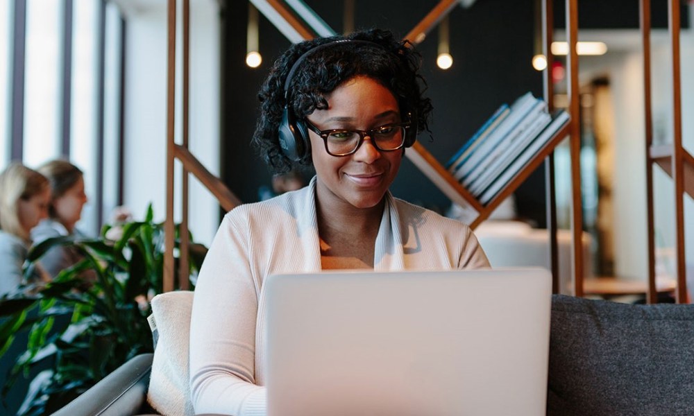 woman working in shared Industrious workspace with laptop.