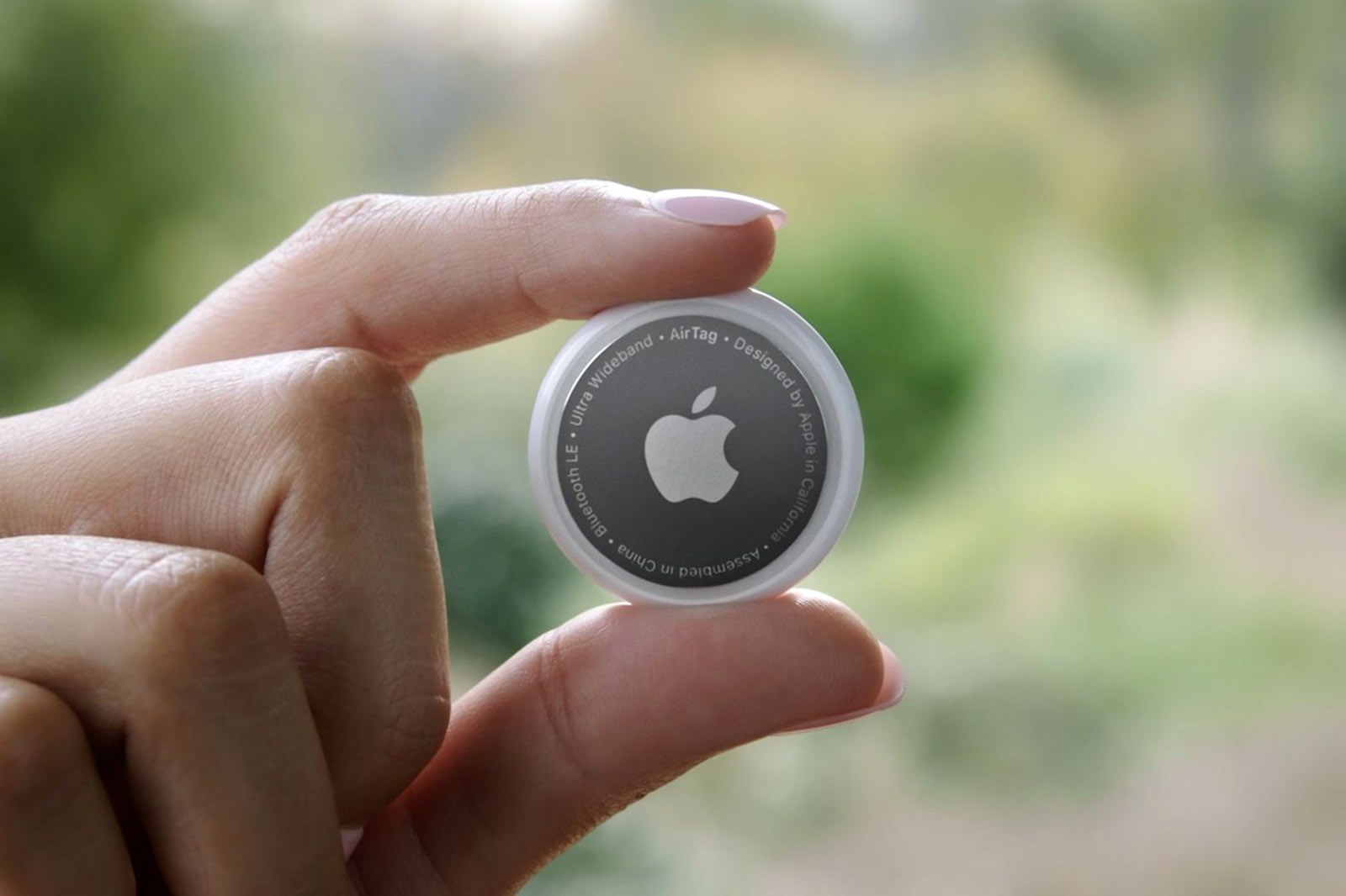 Person holding an Apple AirTag.