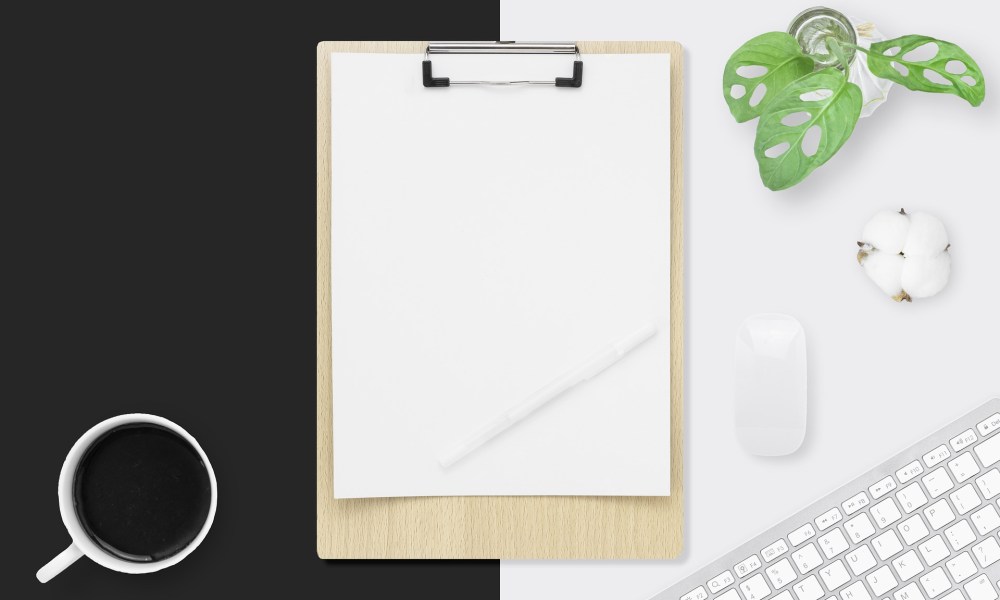 Clipboard on a desk with a Mac keyboard and mouse.