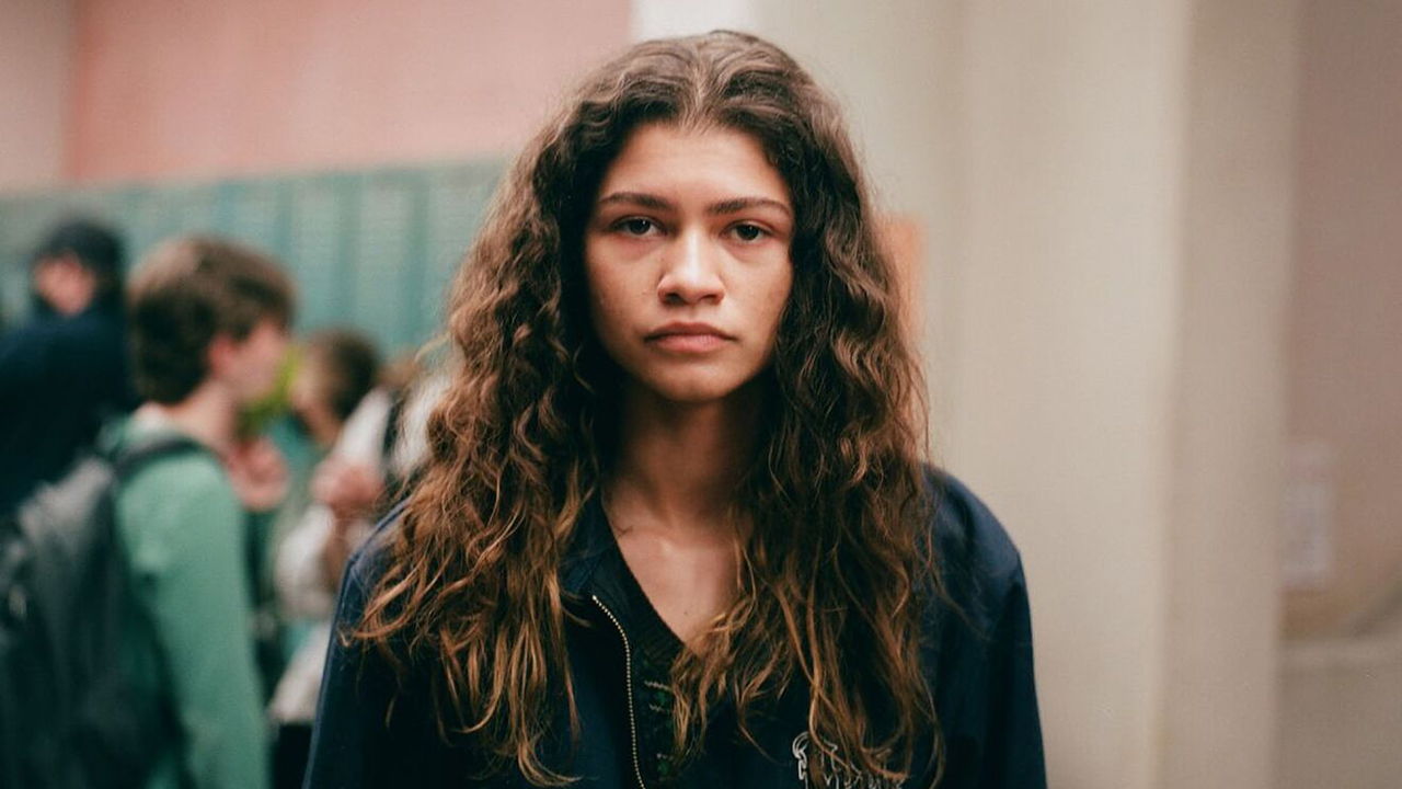 Zendaya mirando directamente a la cámara, con una mirada triste en su rostro, en una escena de la temporada 2 de Euphoria.