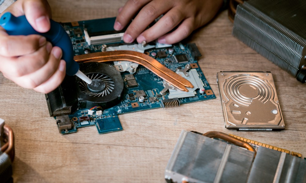 Cleaning a laptop fan with air blower.