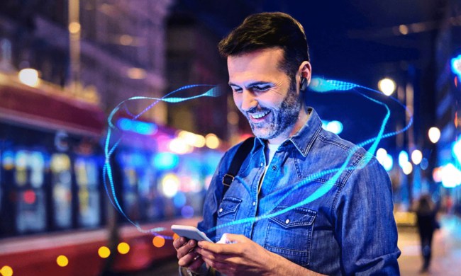 A man listens to his cell phone audio via bluetooth headphones.