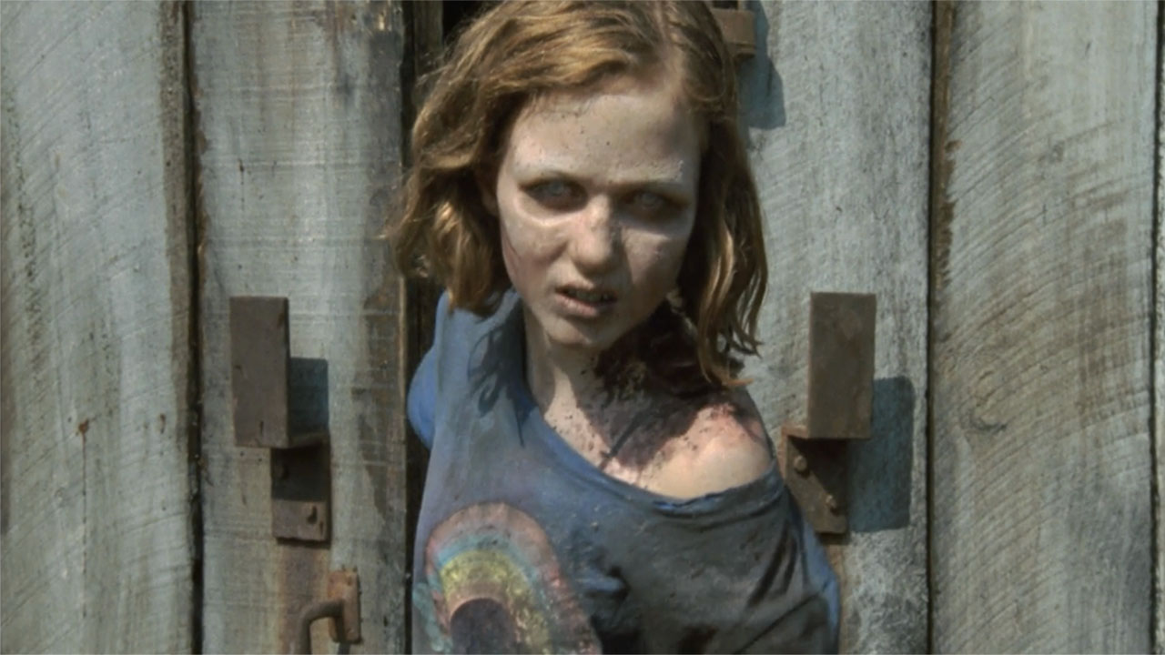 An undead Sophia walking out of the barn door on The Walking Dead.