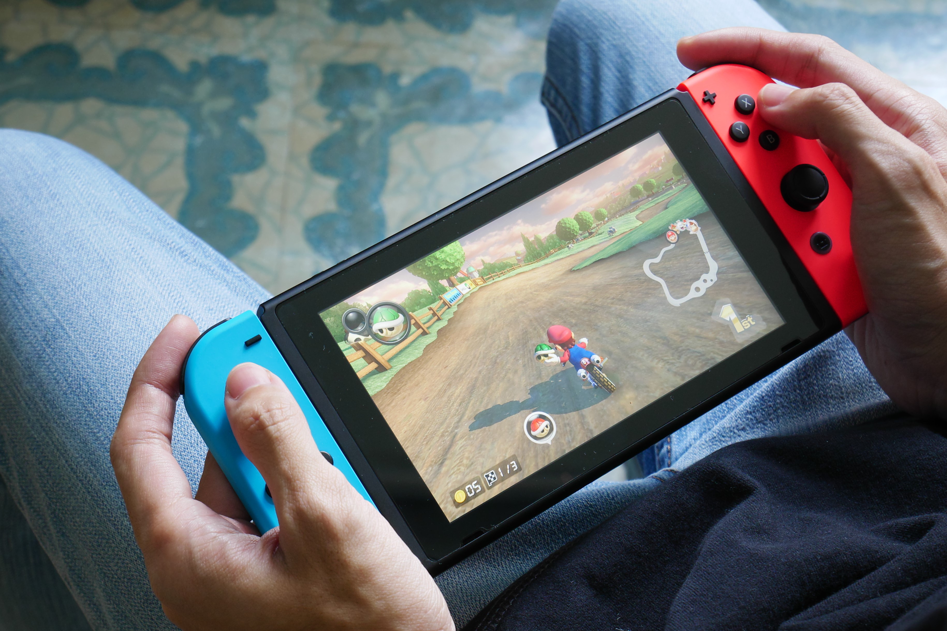 Una persona que juega Mario Kart 8 Deluxe en Nintendo Switch en modo portátil.