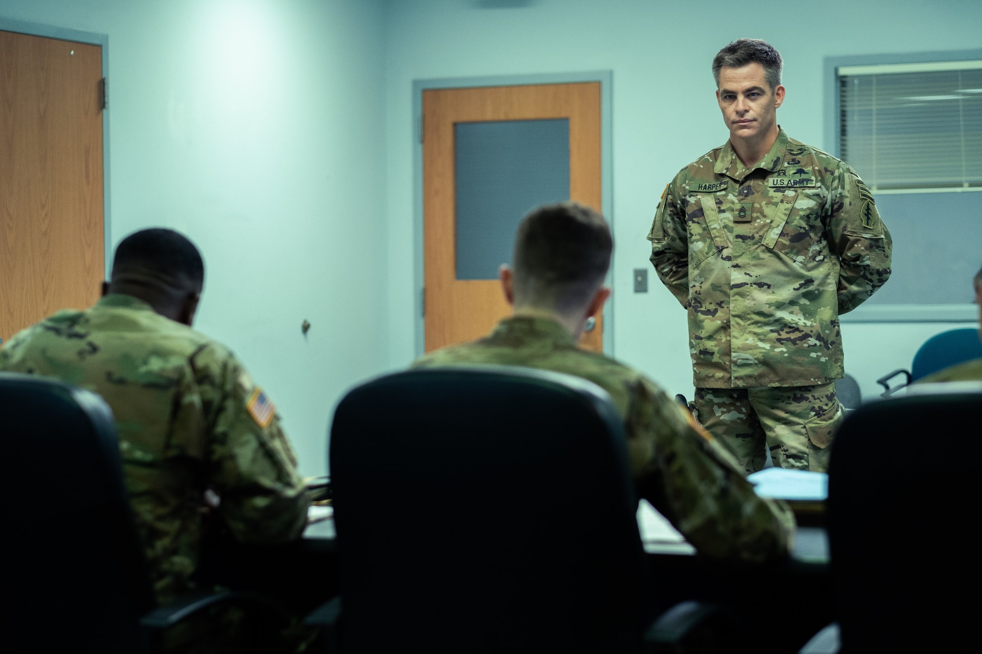 Chris Pine stands in uniform in a scene from The Contractor.