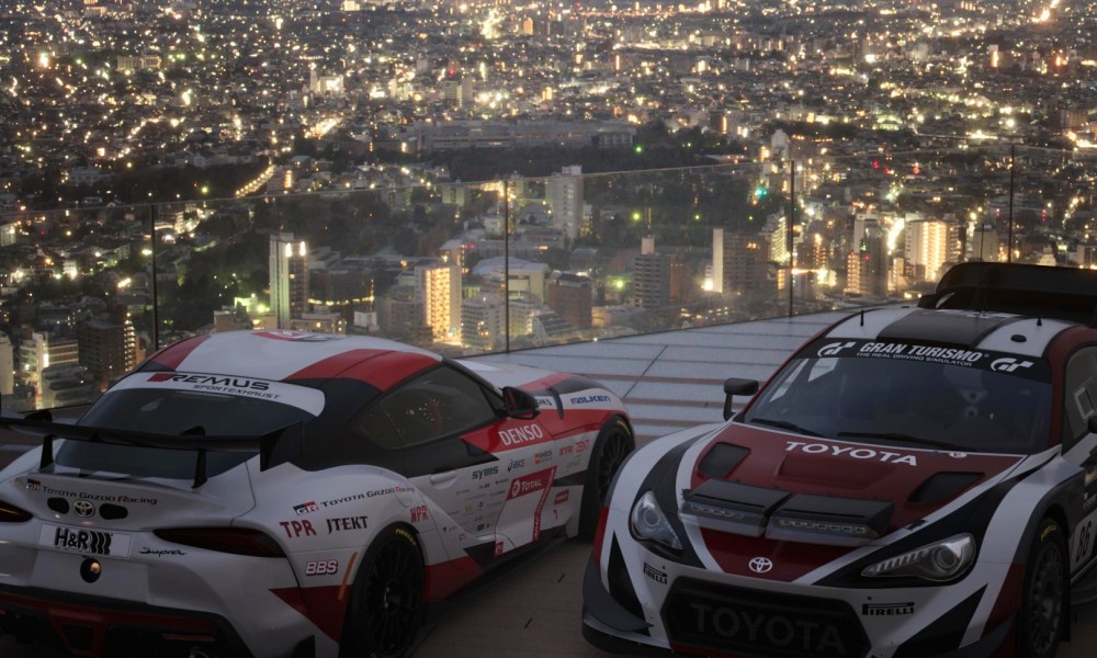 Two sports cars parked side by side on a rooftop in Japan in Gran Turismo 7.