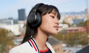 A woman wearing the JBL Live 660NC wireless headphones while outdoors.