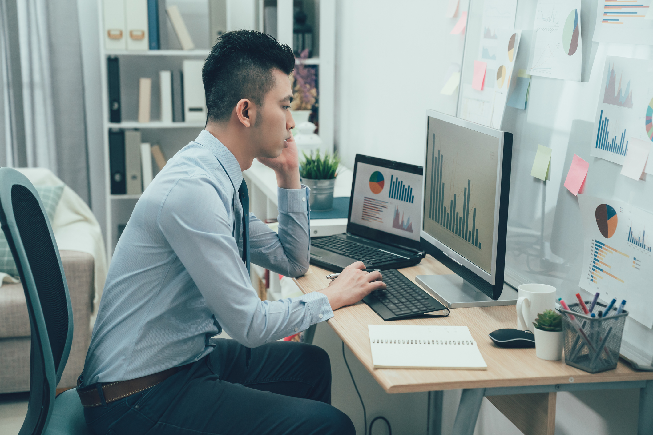 A person looking at bar charts on a PC.