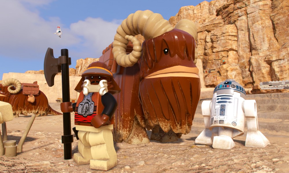 Lando and R2D2 stand by a Bantha in Lego Star Wars: The Skywalker Saga.