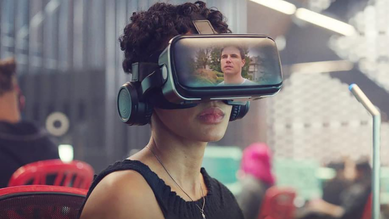 Nora wearing VR glasses showing Nathan in the screen in a scene from Upload on Amazon Prime.