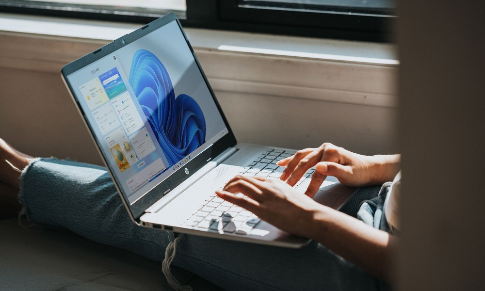 Person sitting and using an HP computer with Windows 11.