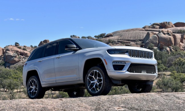 The 2022 Jeep Grand Cherokee 4xe plug-in hybrid perched on a rock.