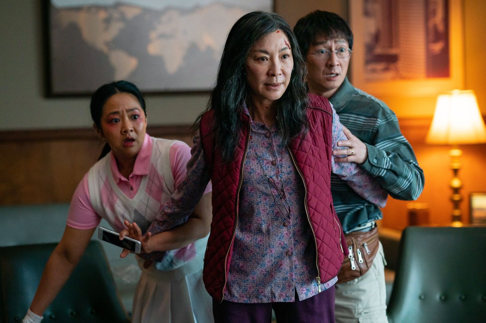 Michelle Yeoh está na frente do marido e da filha de sua personagem em uma cena de Everything Everywhere All At Once.