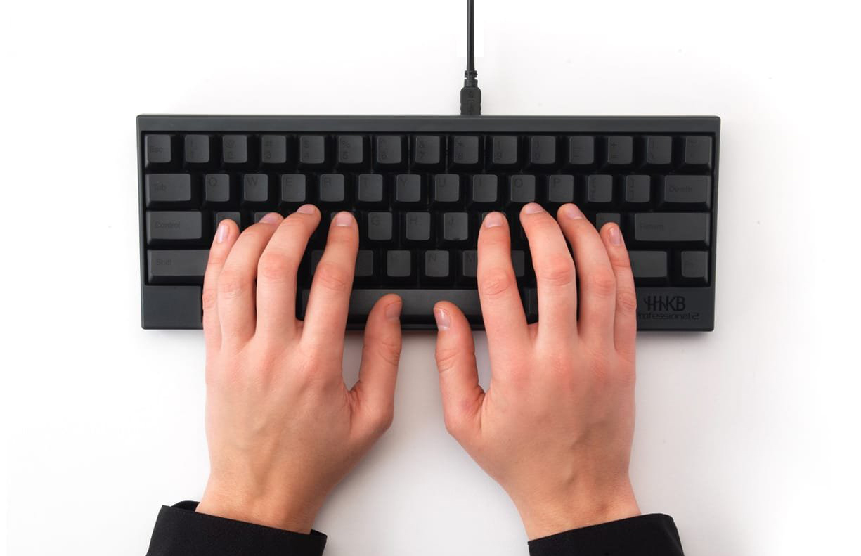 Two hands typing on a Happy Hacking Keyboard Professional 2.