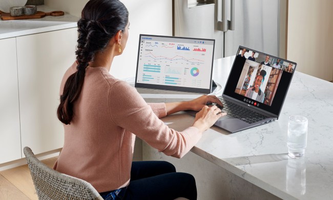 A woman using the LG Gram +view portable monitor with a laptop.