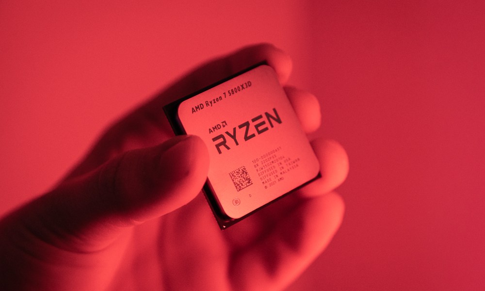 Someone holding the Ryzen 7 5800X3D in a red light.