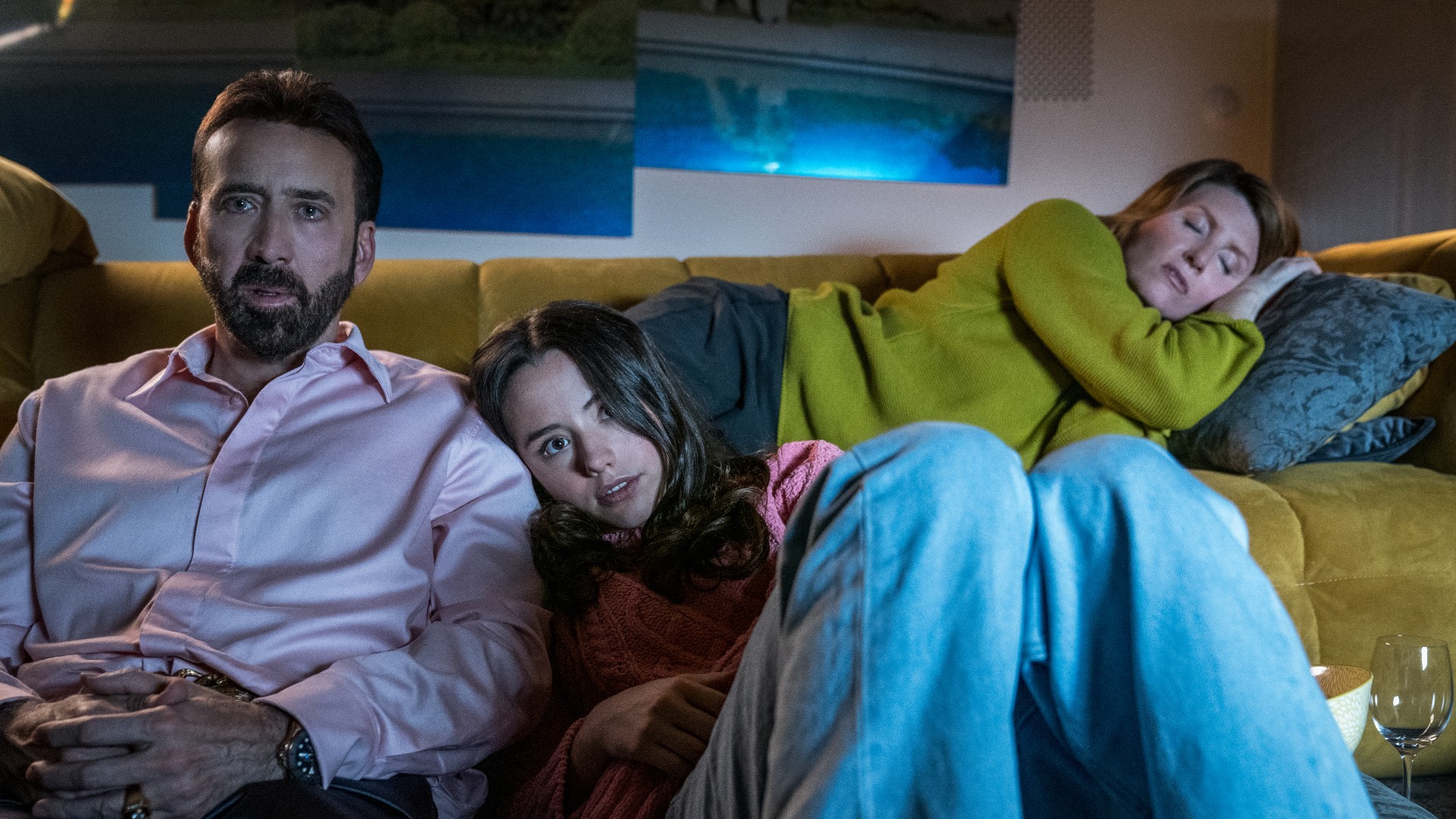 Nicolas Cage y Lily Mo Sheen ven una película mientras Sharon Horgan duerme detrás de ellos.