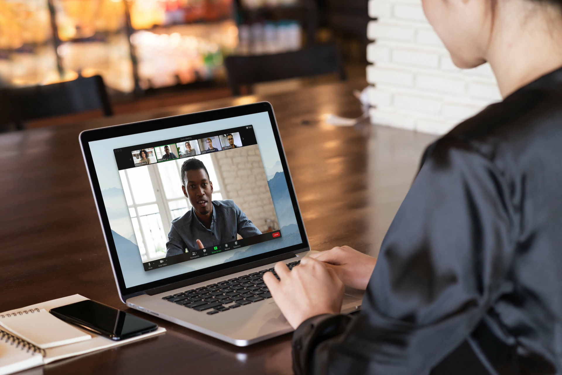 Eine Person führt einen Zoom-Anruf auf einem Laptop durch, während sie an einem Schreibtisch sitzt.