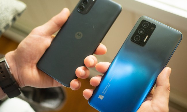 A person holding a Moto G 5G and Blu F91 5G smartphone in each hand