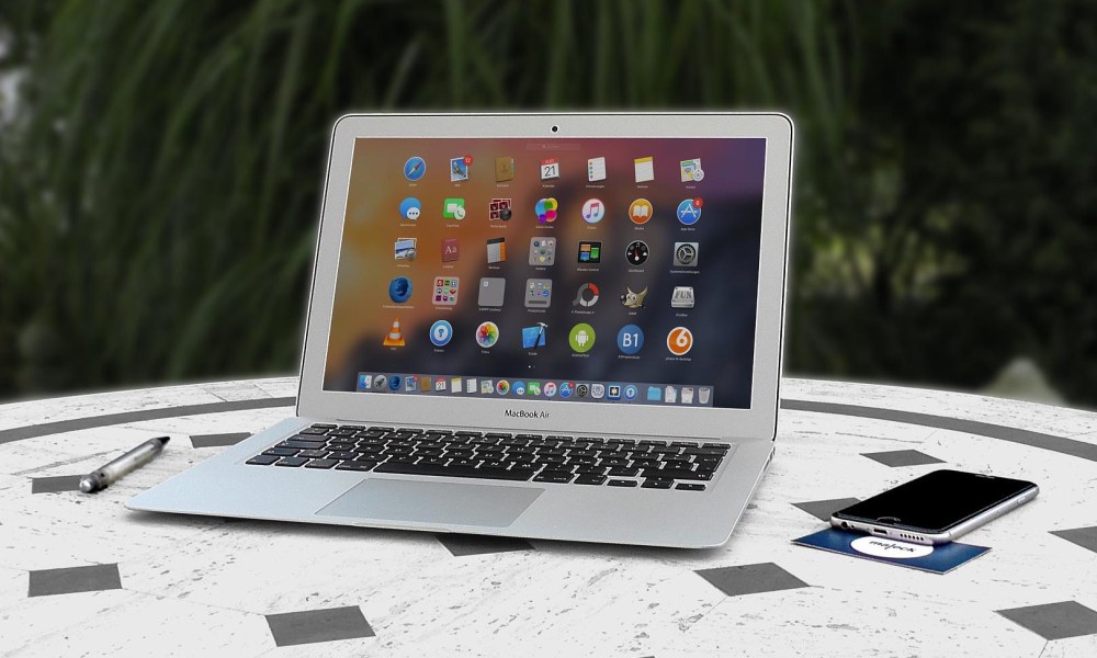 MacBook Air on a patio table, outdoor office.