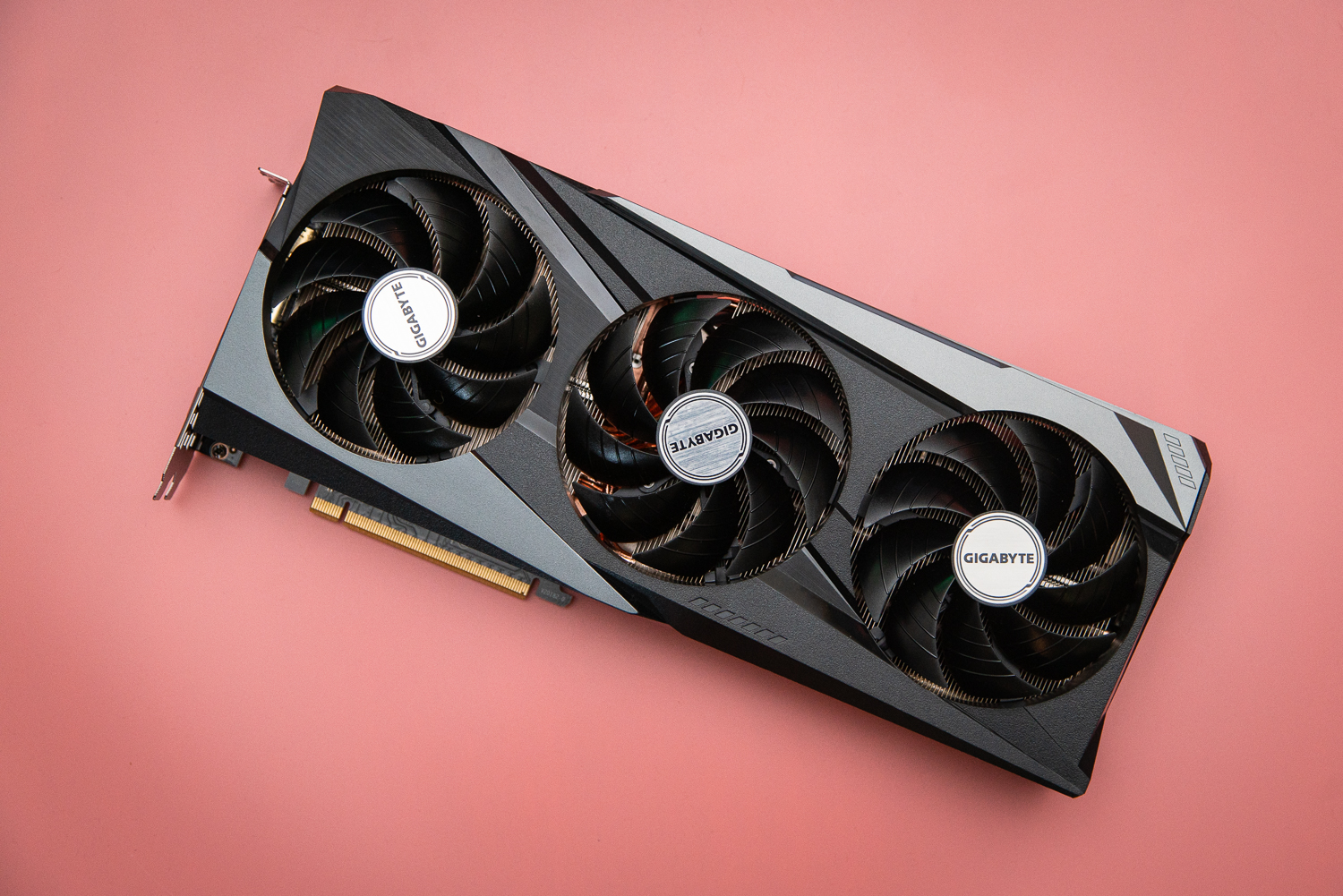 गुलाबी पृष्ठभूमि पर AMD RX 6950 XT ग्राफ़िक्स कार्ड।