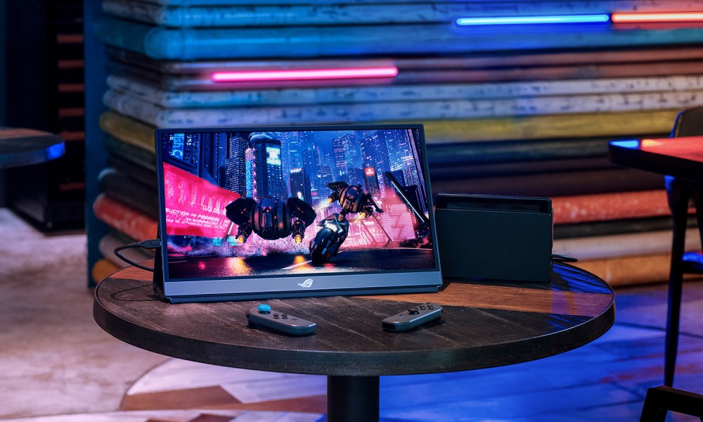 The ASUS ROG Strix XG16AHPE portable gaming monitor next to a Nintendo Switch.