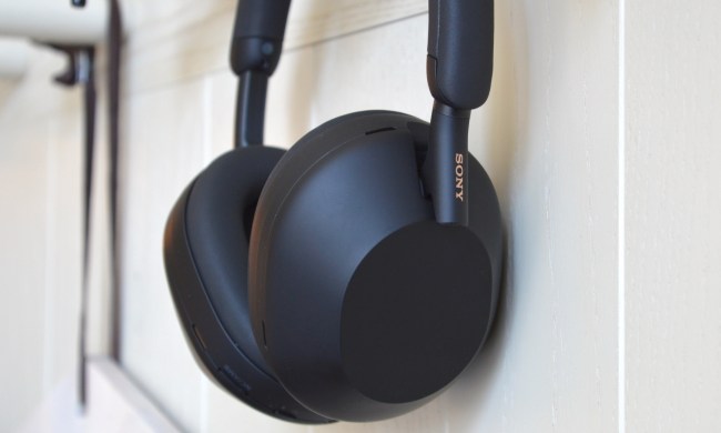 Sony WH-1000XM5 wireless headphones hanging on a wall hook.