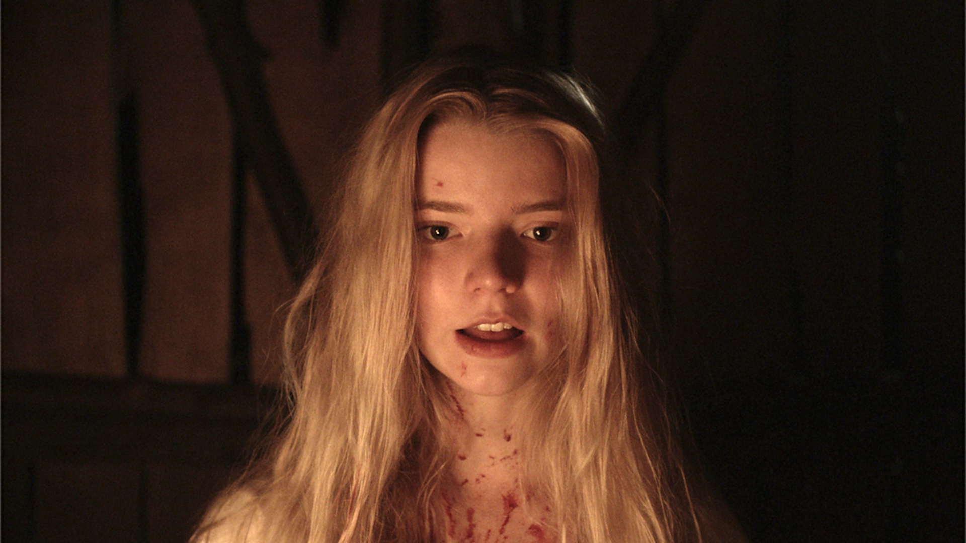 Thomasin looking at the camera with a satisfied expresion on her face in The Witch.