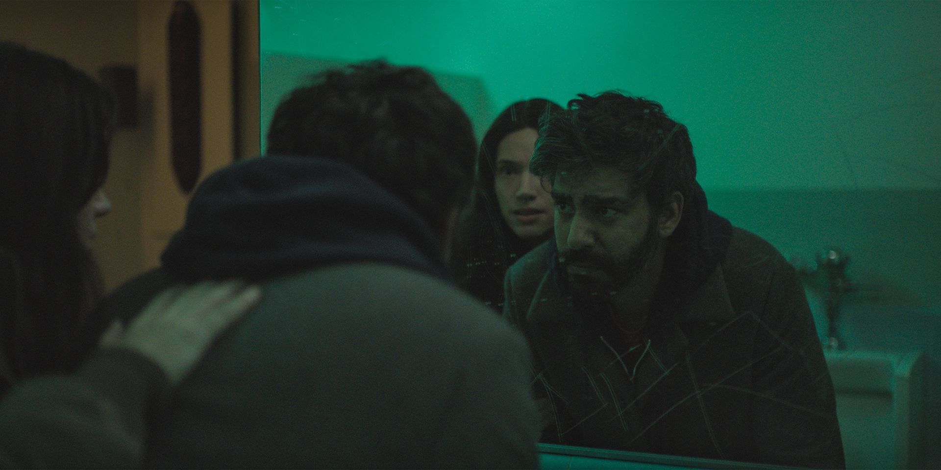 Katie Parker debout derrière Rahul Kohli dans une salle de bain dans une scène de Next Exit.