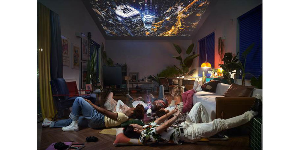 A group of people lying down in a room watching the Samsung Freestyle Projector in action.