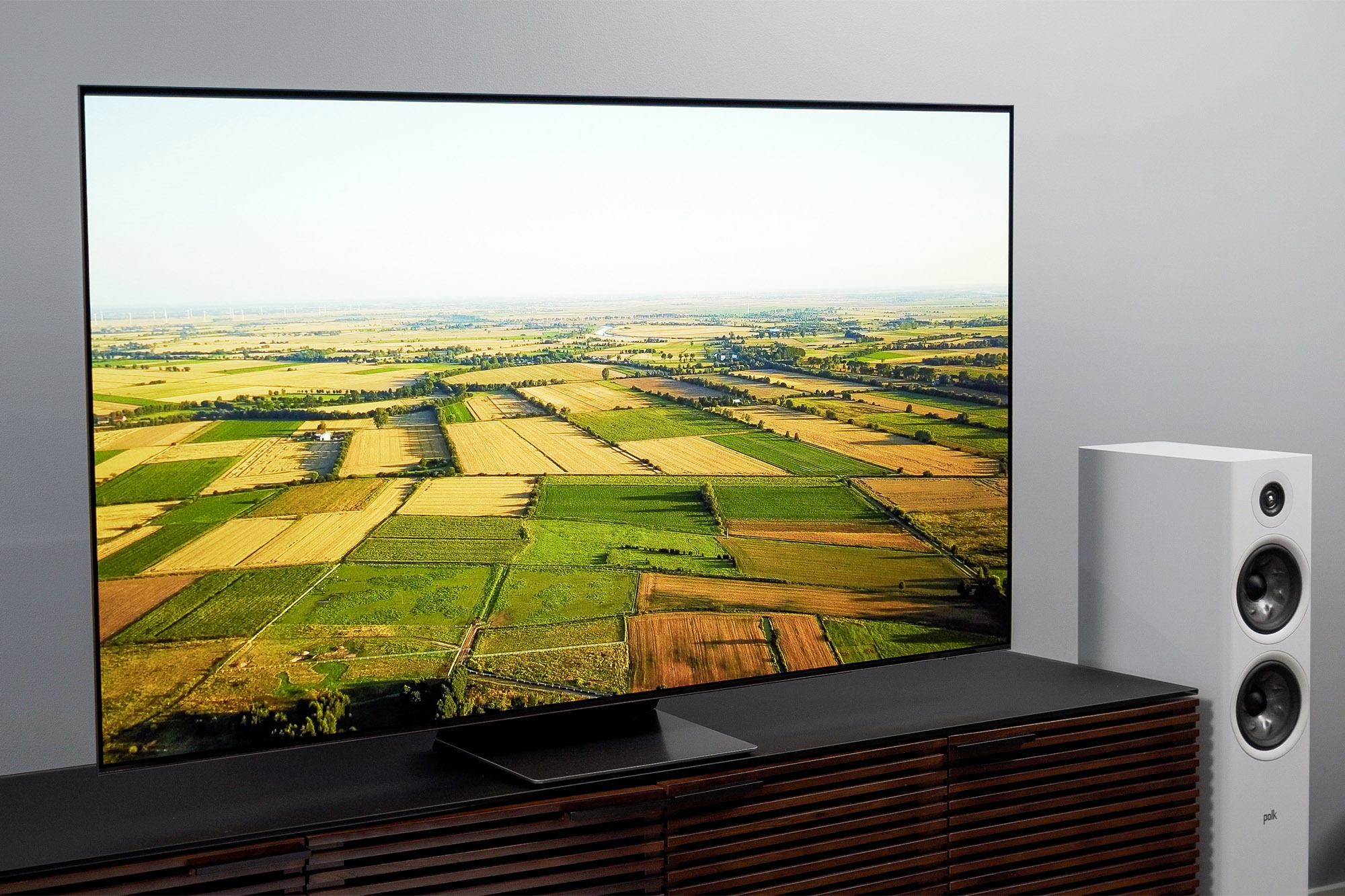 Eine schräge Ansicht des Samsung S95B OLED mit einem Bild einer Farm, das auf dem Bildschirm angezeigt wird.