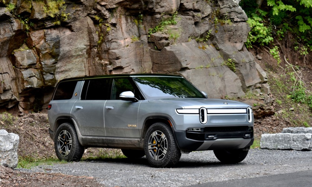 The front three-quarter view of a 2022 Rivian against a rocky backdrop.