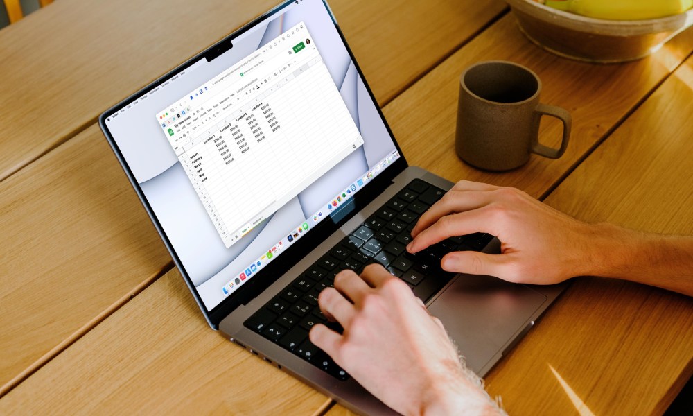 A MacBook on a table using Google Sheets.