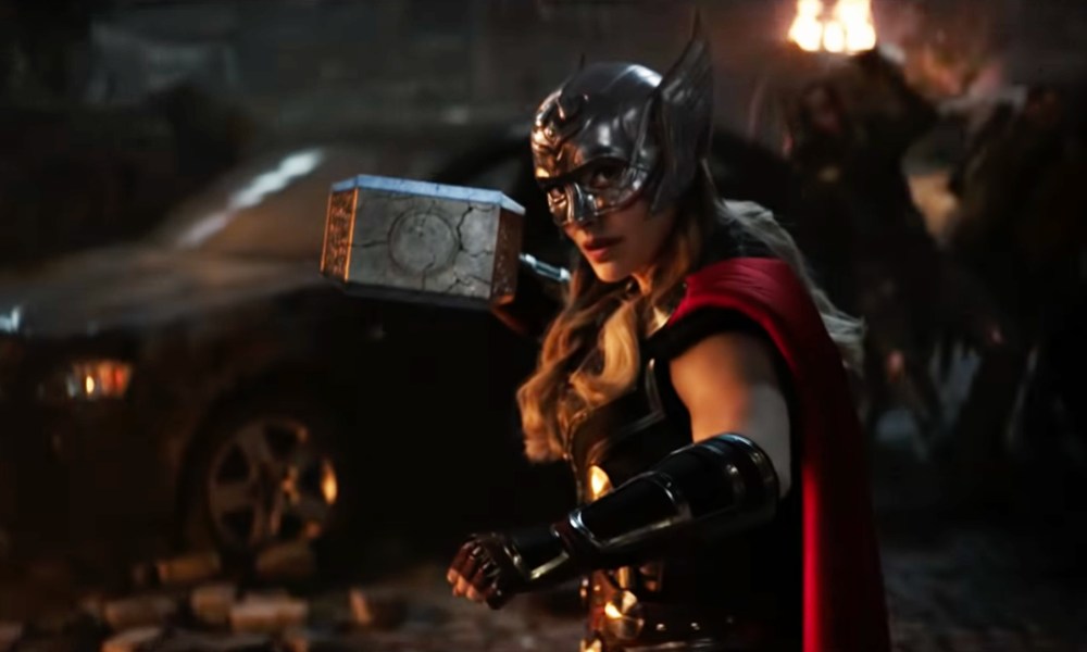 Natalie Portman in costume as Mighty Thor and wielding Mjolnir in Love and Thunder.