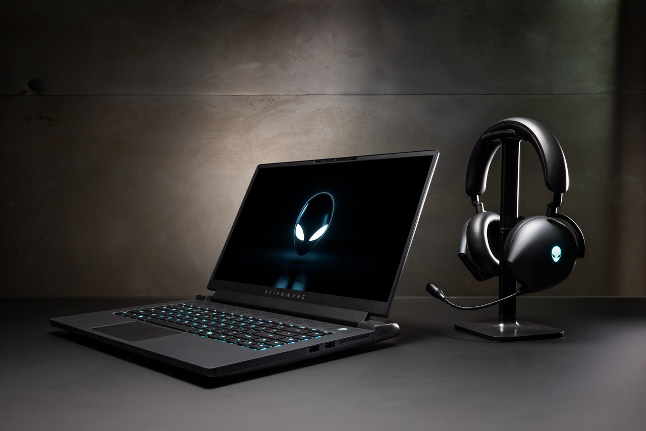 Laptop Alienware m17 R5 sentado ao lado de um fone de ouvido.