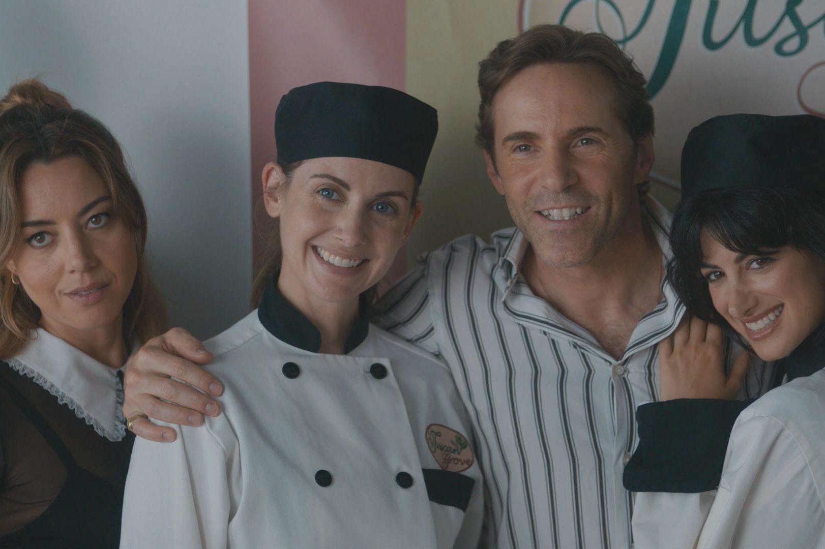 Aubrey Plaza, Alison Brie, Alessandro Nivola e Ayden Mayeri posam para uma foto em uma cena de Spin Me Round.