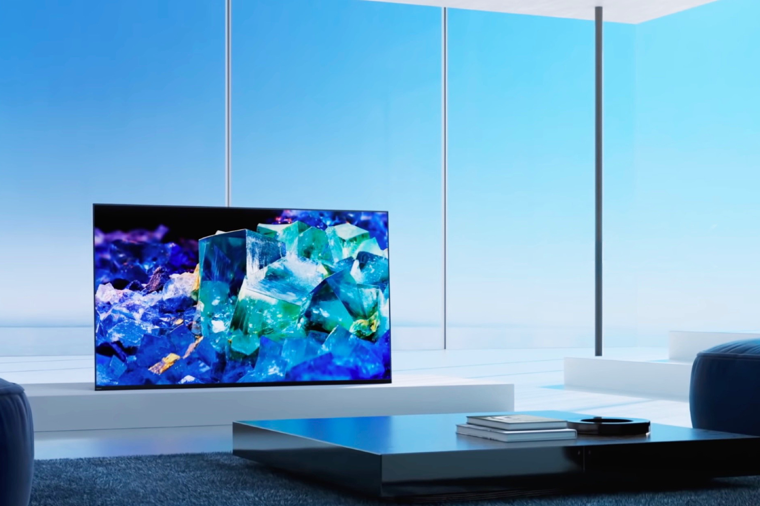 A Sony Bravia A80K 4K TV sits on the table in front of the large screen.