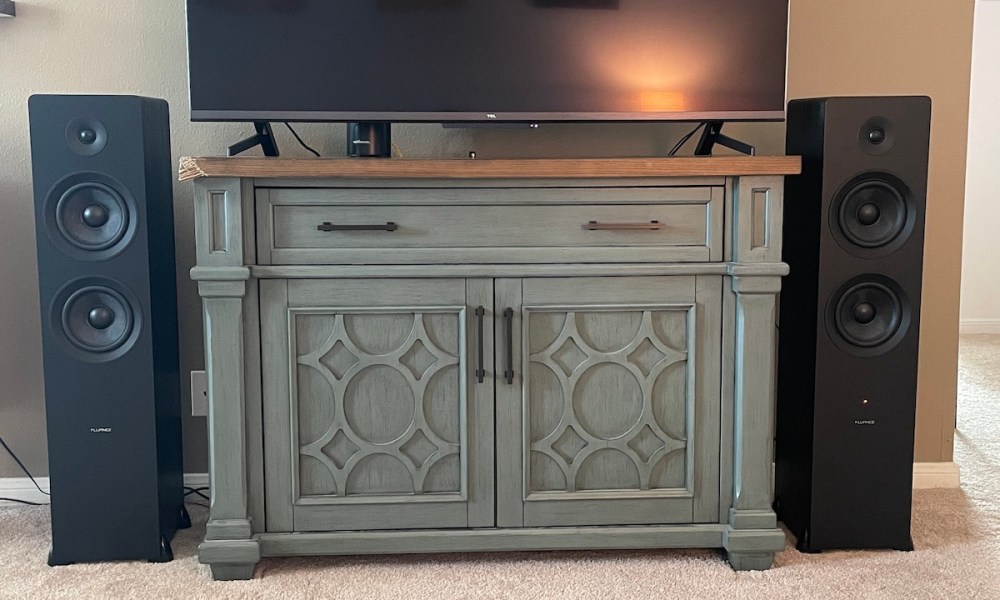 The Fluance Ai81 speakers set up on each side of a TV stand.