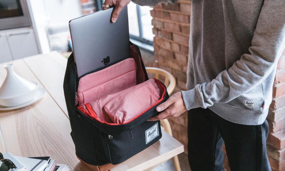 Someone sliding a Macbook into the Herschel Pop Quiz backpack