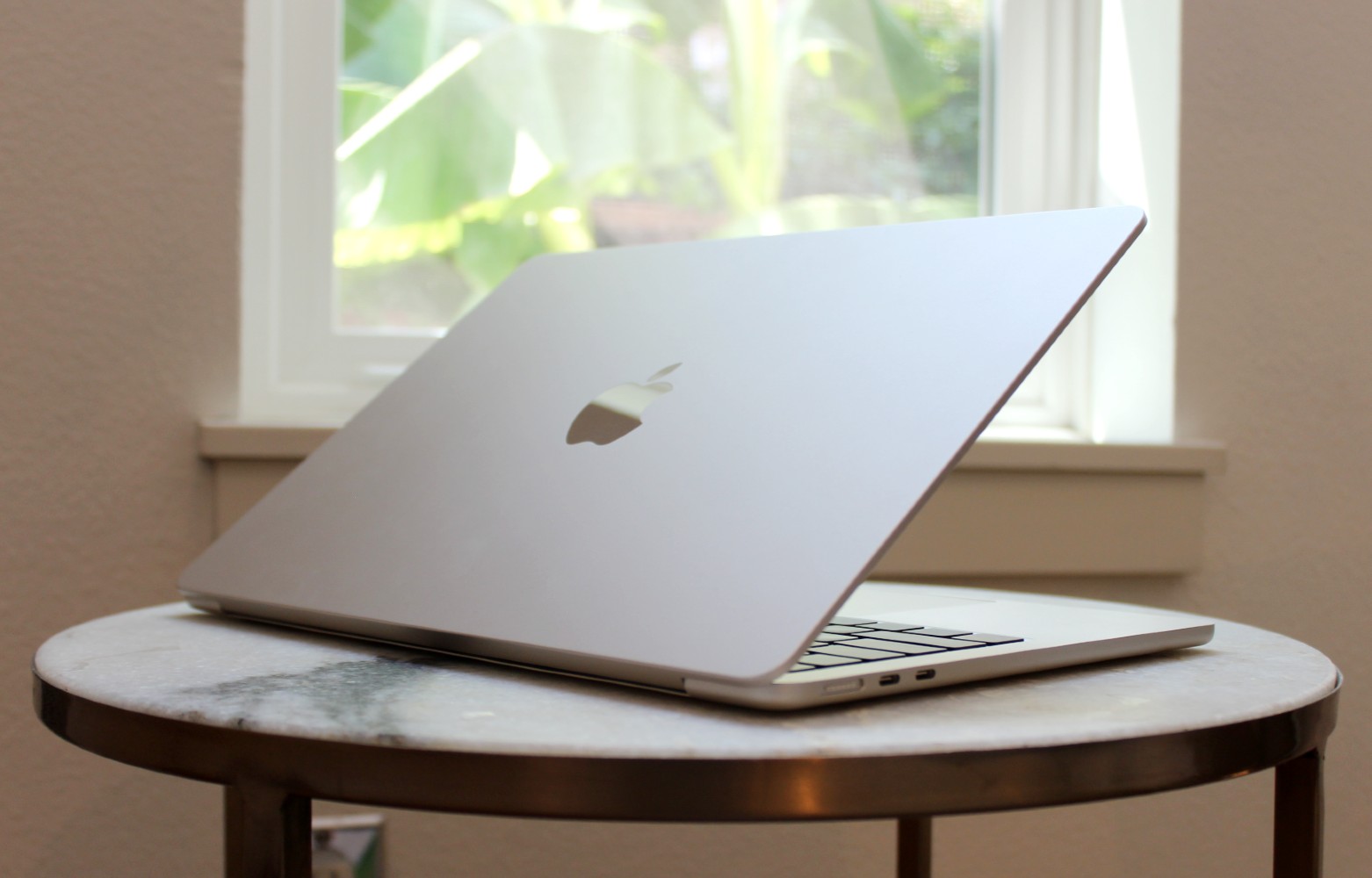 Das MacBook Air auf einem Tisch vor einem Fenster.
