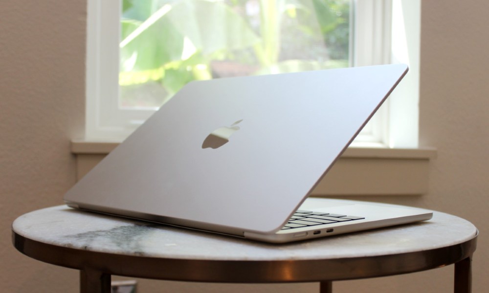 The MacBook Air on a table in front of a window.