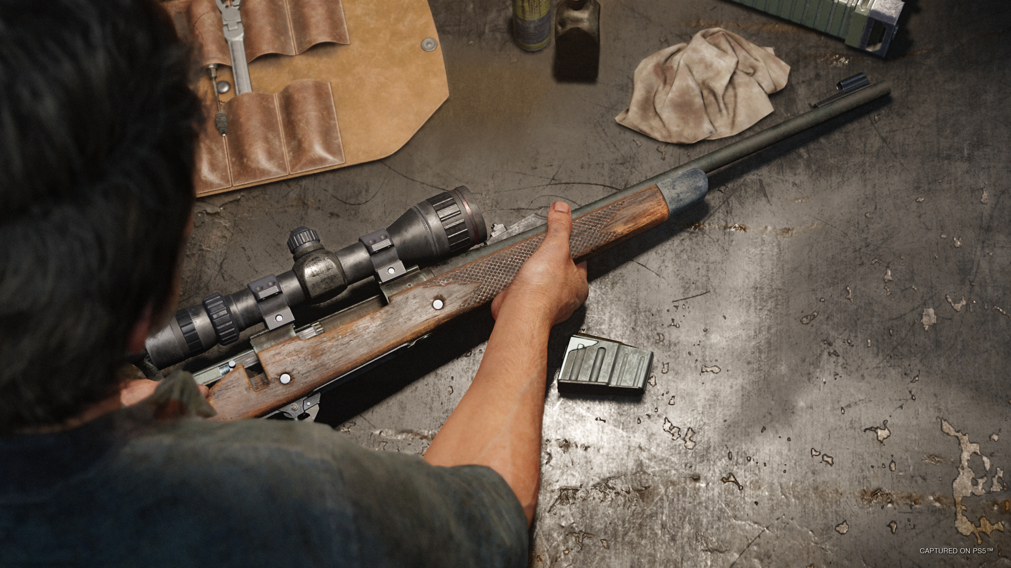 Joel place un fusil sur une table dans The Last of Us Part I.