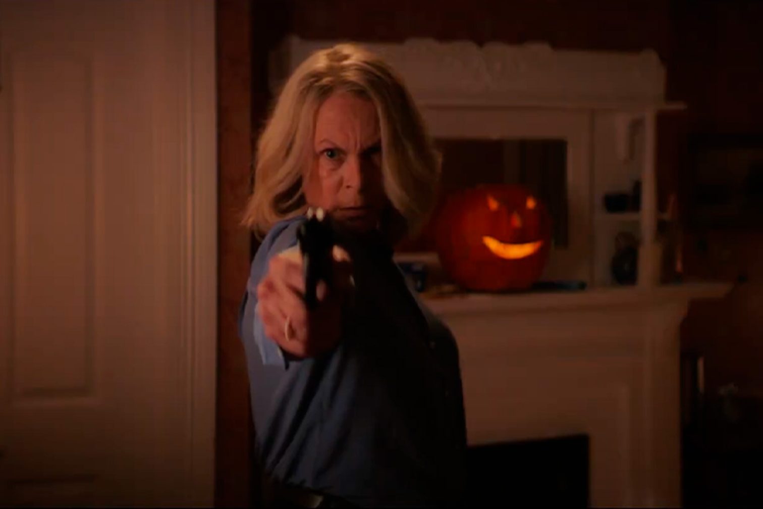 Jamie Lee Curtis sostiene un arma en una escena de Halloween Ends.