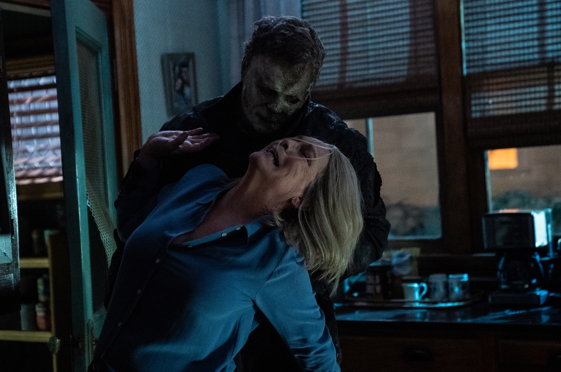 Michael Myers sostiene a Lauri Strode de Jamie Lee Curtis por el cuello en una escena de Halloween Ends.