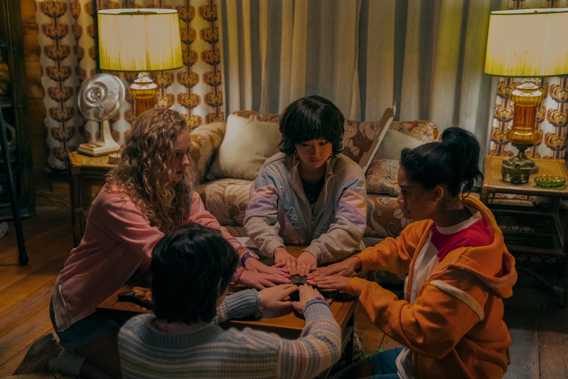 In My Best Friend's Exorcism versammelt sich eine Gruppe Mädchen um ein Ouija-Brett.